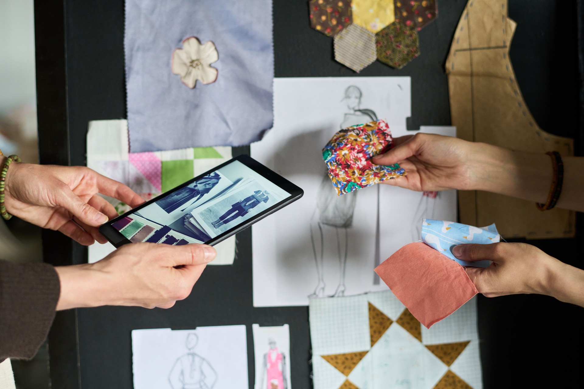 Caucasian Woman and Man Collaborating on Fashion Design Project Using Tablet