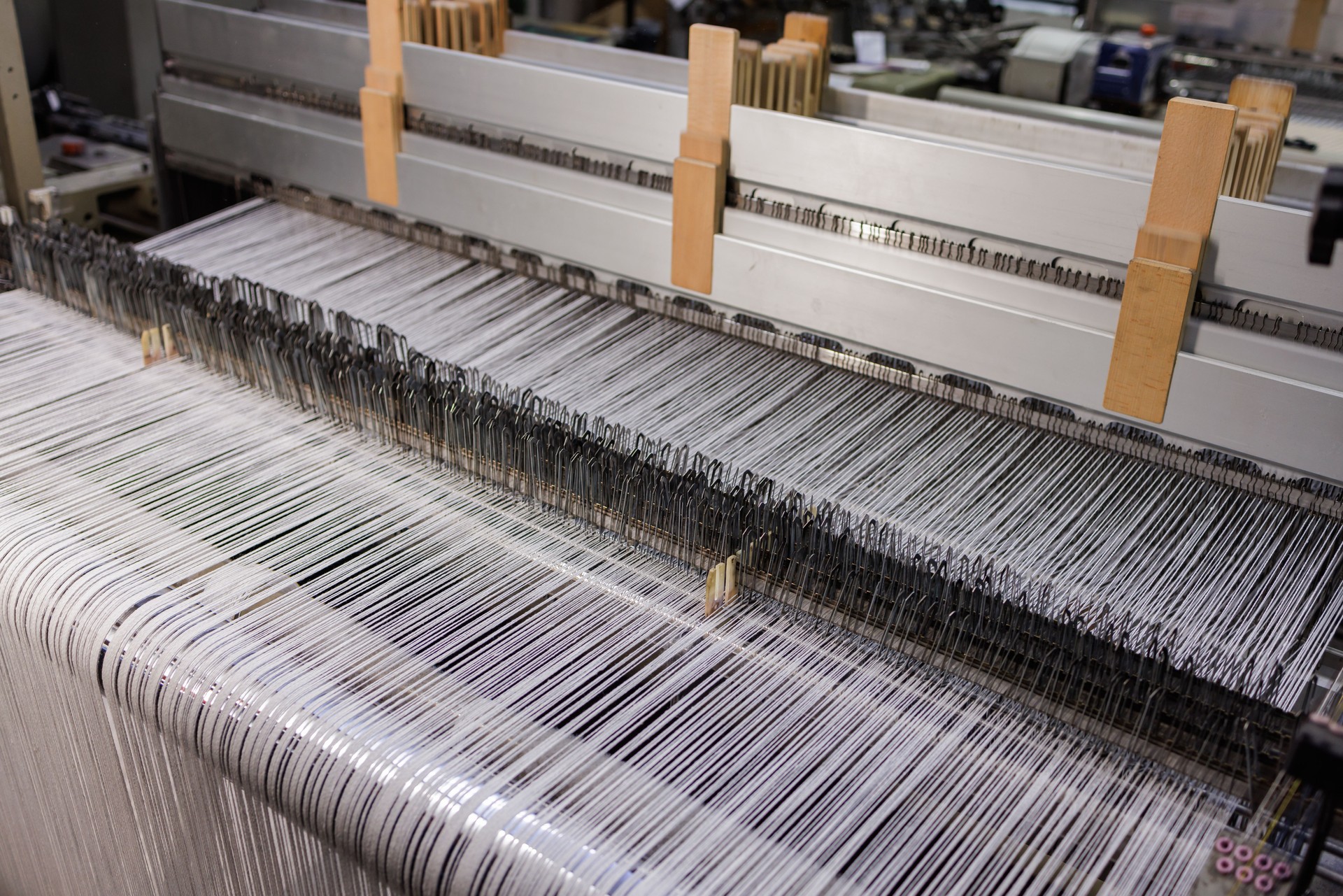 A close up of weaving machine. A loom machine for clothing or woven label. Weaving machine for garment industry.